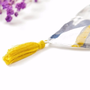 Detail of grey abstract floral cotton linen scarf with vibrant yellow tassel fringe