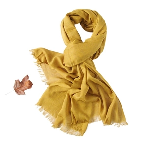 Ginger yellow linen scarf with subtle sequins and tassels on white background