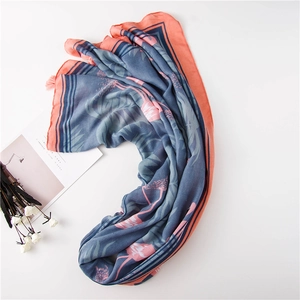 Détail de l'écharpe corail et bleue avec imprimé flamant et bords à franges fins