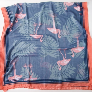 Détail de l'imprimé flamant rose et feuilles de palmier sur châle bleu brume