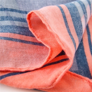 Texture détaillée de l'écharpe en coton et lin avec motif à rayures corail et bleu gris