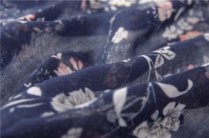 Dettaglio macro della sciarpa in cotone e lino blu navy con stampa floreale fine