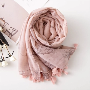 Pink cotton linen scarf with floral print and fringe tassels on a white background
