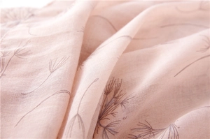 Detailed close-up of light pink cotton linen scarf with elegant dandelion flower prints