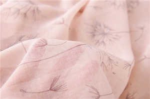 Macro detail of soft light pink scarf fabric with delicate dandelion floral print