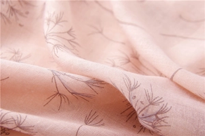 Close-up of pink cotton linen scarf featuring delicate purple dandelion floral print