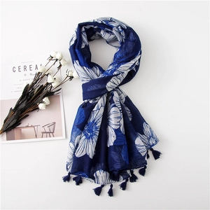 Navy blue cotton linen scarf with white floral print and tassel edges on white surface