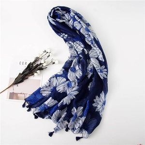 Detailed view of floral pattern and fringe tassels on a navy blue cotton linen scarf