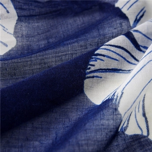 Detailed macro view of semi-transparent blue cotton linen scarf with white floral print