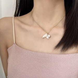 Élégant collier doré avec pendentif queue de poisson en nacre et perle sur mannequin
