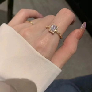 Elegant gold-plated ring featuring a rectangular zircon and pavé diamonds on a model's hand