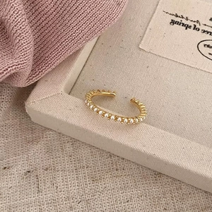 Elegant gold-plated adjustable ring featuring minimalist white pearls in a row