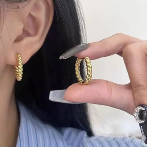 Elegant gold twisted hoop earrings with a delicate spiral texture for daily style