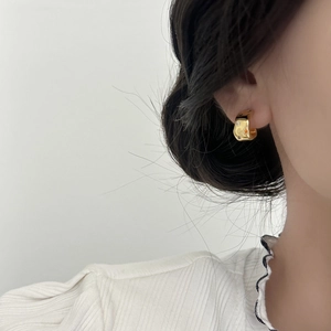 Boucles d'oreilles créoles dorées avec étoile en zircone sur un modèle féminin