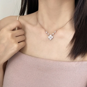 Collier trèfle rose serti de zircons en finition or rose porté par une femme