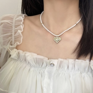 Collier de perles élégant de style français avec pendentif cœur doré sur un mannequin
