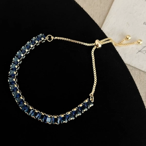 Close-up of adjustable gold bracelet with square-cut dark blue zircon stones