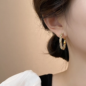 Textured gold hoop earrings with sparkling hammered finish worn by a model