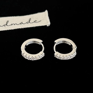 Gros plan sur des boucles d'oreilles huggies en argent serties de zircons brillants