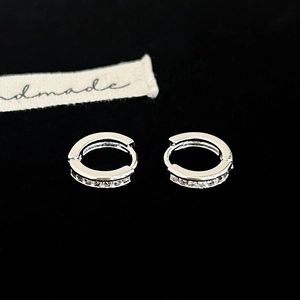 Vue détaillée des boucles d'oreilles créoles en argent serties de zircone brillant