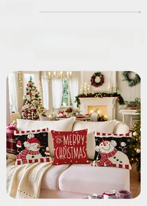 Detail of Christmas pillow cases with snowman and Merry Christmas text on a white sofa