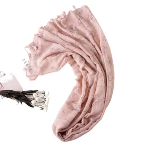 Pink floral cotton scarf with dandelion print and fringed edges on a clean background