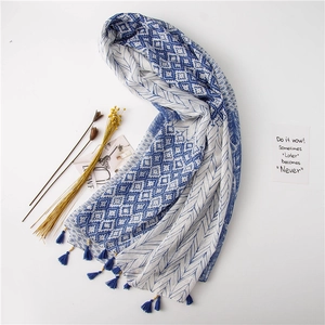 Détail d'écharpe ethnique bleue et blanche avec motifs géométriques et franges