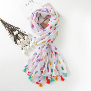Cotton linen scarf with colorful polka dots and tassels on a minimalist background