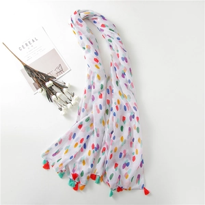 Detailed shot of white cotton linen scarf with colorful polka dots and fringe trim