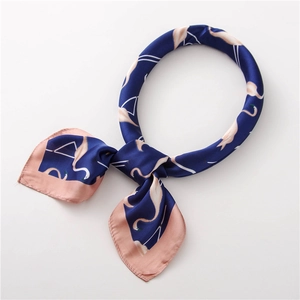 Détail d'un foulard en satin avec imprimés flamants roses sur tissu en soie marine