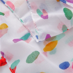 Macro view of cotton linen scarf with colorful polka dots and red tassel details