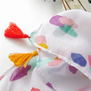 Detail of colorful dots on cotton linen scarf with vibrant red and yellow tassels