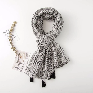 Detail of a lightweight linen scarf featuring black seed prints and elegant fringe tassels