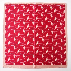 Détail d'un foulard carré en soie à imprimé flamants roses et bordure en satin rose