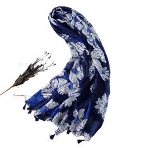 Navy blue cotton linen scarf with white floral print and tassel edges on white background