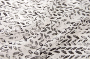 Detailed close-up of soft cotton linen scarf with black and white abstract print texture