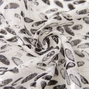 Macro detail of soft cotton linen scarf fabric with metallic silver leaf print and fringe