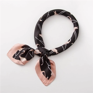 Détail d'un foulard en soie avec imprimé flamant rose et texture élégante sur fond noir
