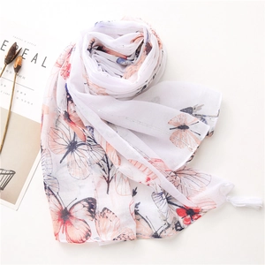 Detailed texture of white butterfly print scarf with silver metallic thread and tassels