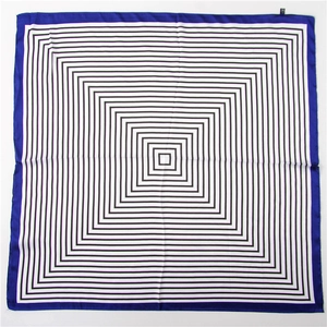 Détail d'un carré de soie avec motif géométrique noir et blanc et bordure bleue