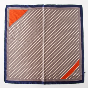 Detail eines Seidenschals mit geometrischen Mustern, marineblauen Rändern und orangefarbenen Streifen