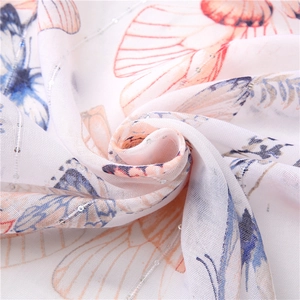 Detail of white butterfly print scarf with delicate silver sequins and soft fabric texture