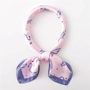 Détail d'un carré de soie rose avec motifs flamants roses et bordures violettes