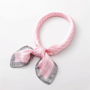 Détail de l'élégant foulard en soie rayé rose et gris avec un nœud à motif en V