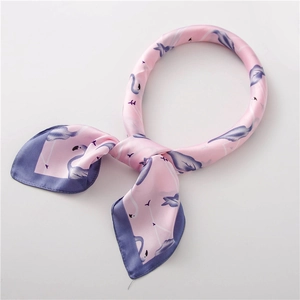 Vue détaillée du foulard en soie rose avec motifs de flamants bleus et bordure contrastée