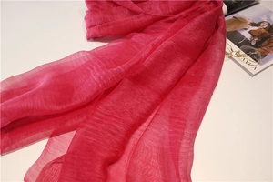 Vue détaillée d'une écharpe en soie magenta avec une texture plissée élégante