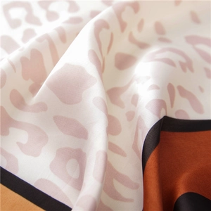 Detailed macro shot of soft leopard print silk scarf with pink and ivory textures