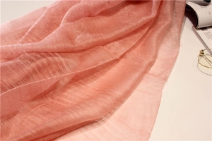 Gros plan sur l'écharpe en soie et laine rose saumon avec textures horizontales