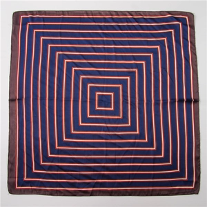 Carré de soie à plat avec motifs géométriques bleu marine et texture soyeuse et brillante
