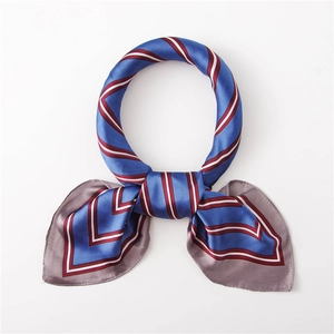 Gros plan du foulard en soie bleu roi rayé montrant la texture satinée et le nœud